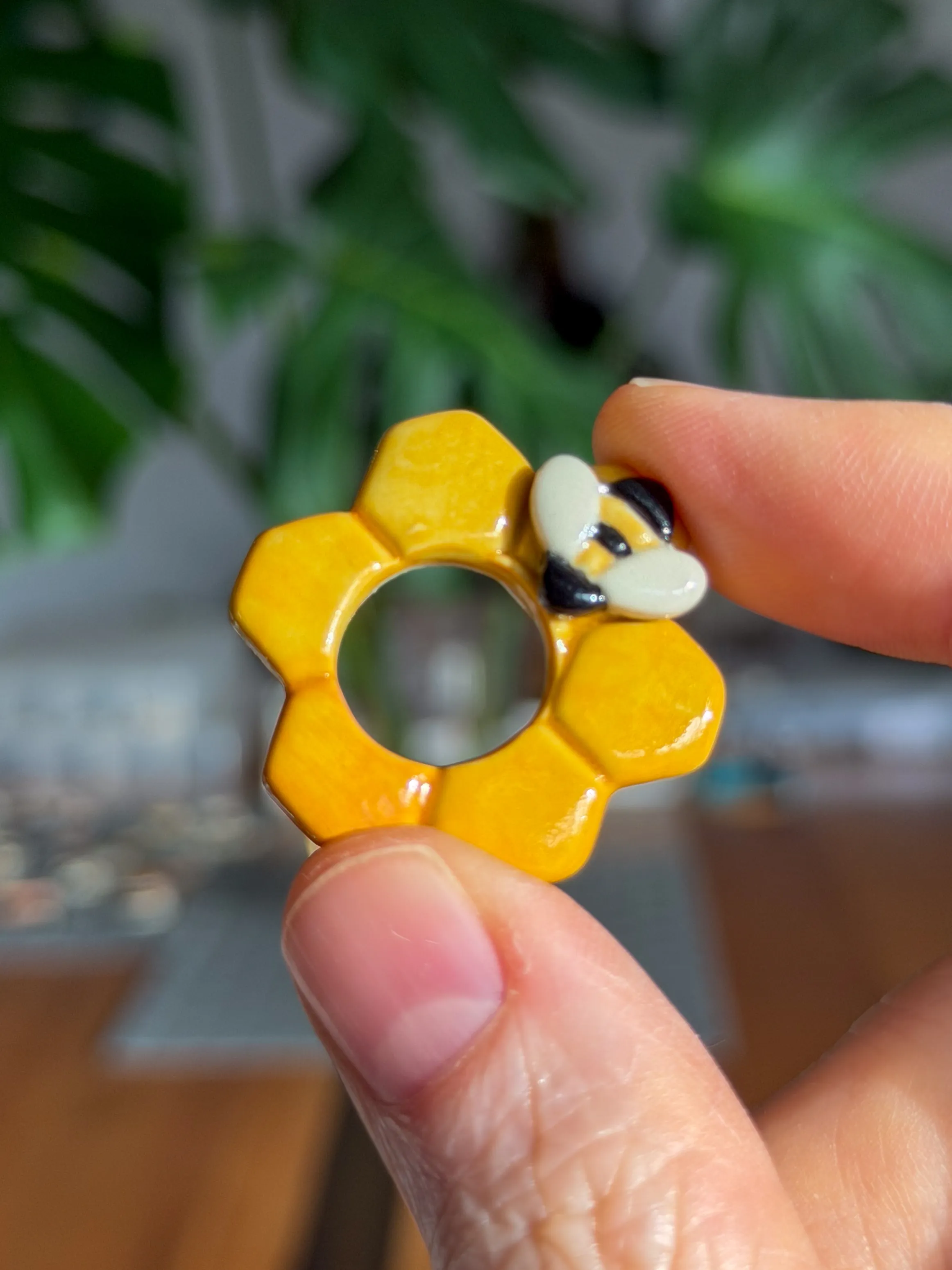 Yellow flower-shaped ceramic pendant with a tiny bee