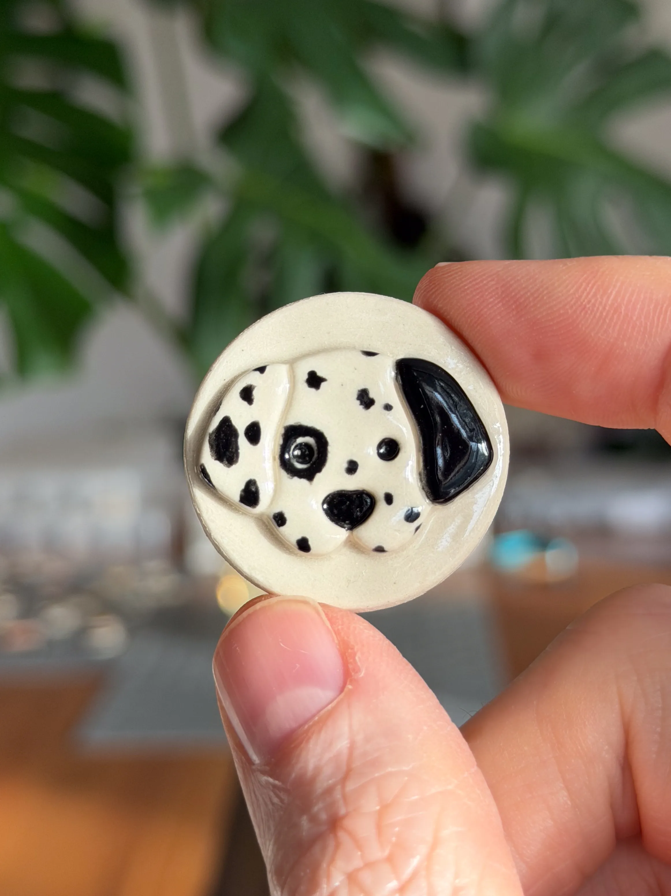 Hand-sculpted ceramic brooch of a Dalmatian puppy face