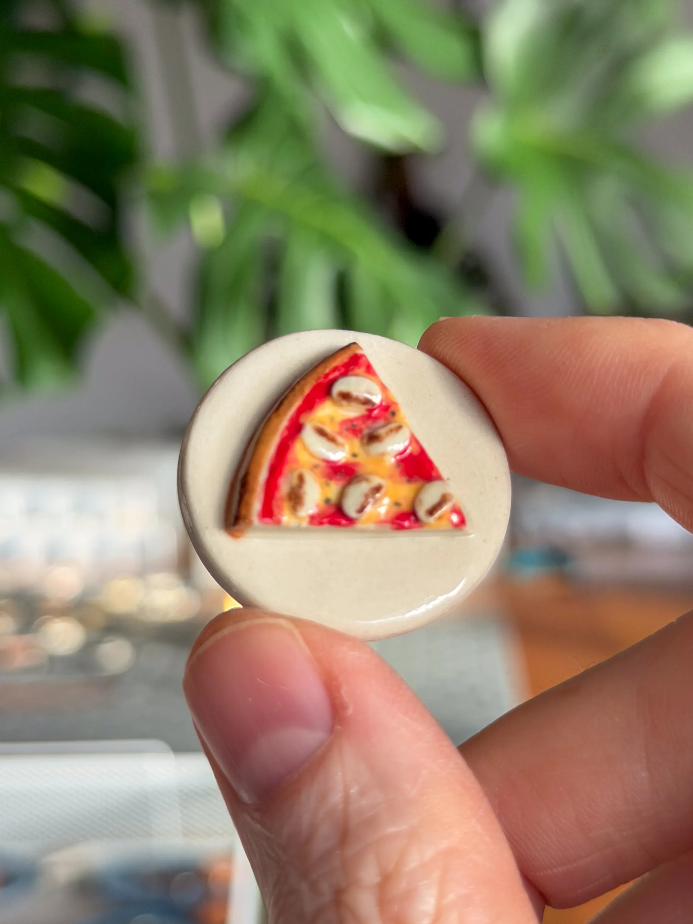 Hand-sculpted ceramic brooch of a pepperoni pizza slice
