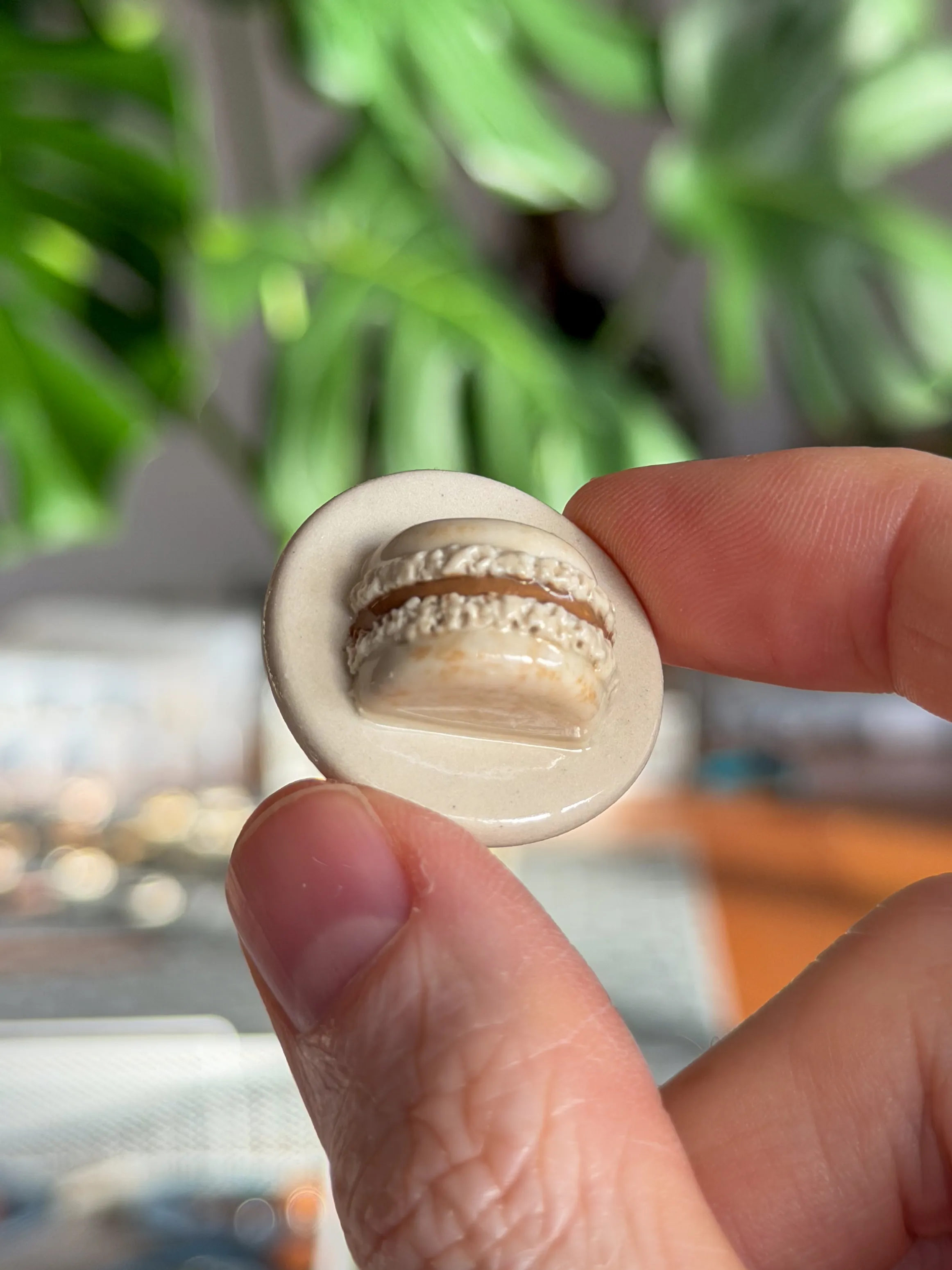 Hand-sculpted ceramic brooch shaped like a cream macaron
