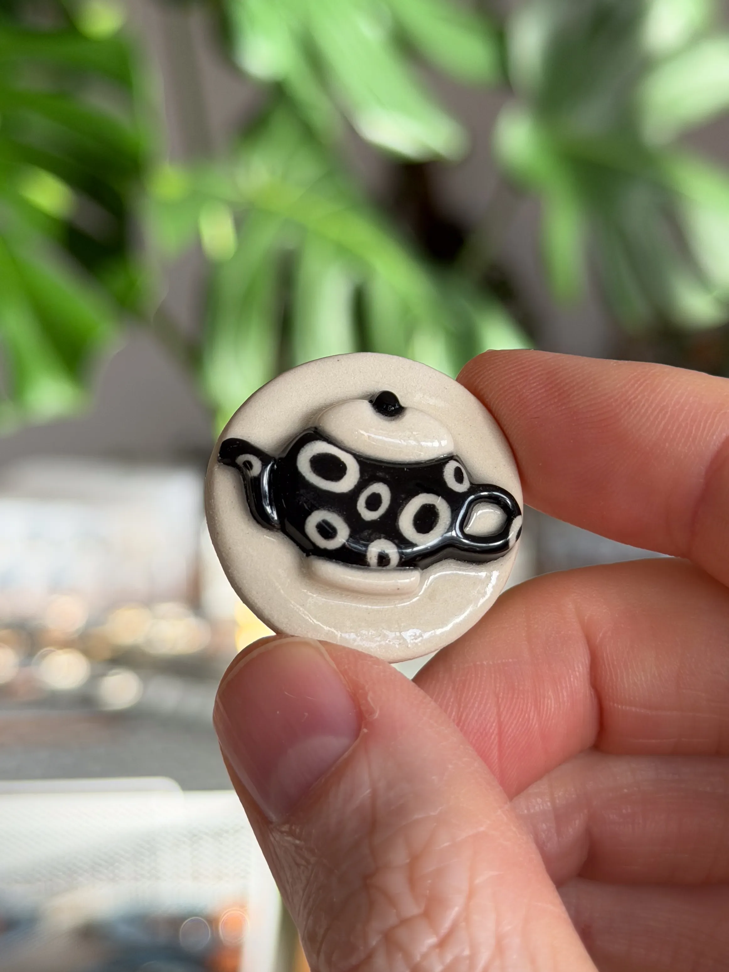 Cream ceramic brooch with a hand-painted black-and-white spotted teapot