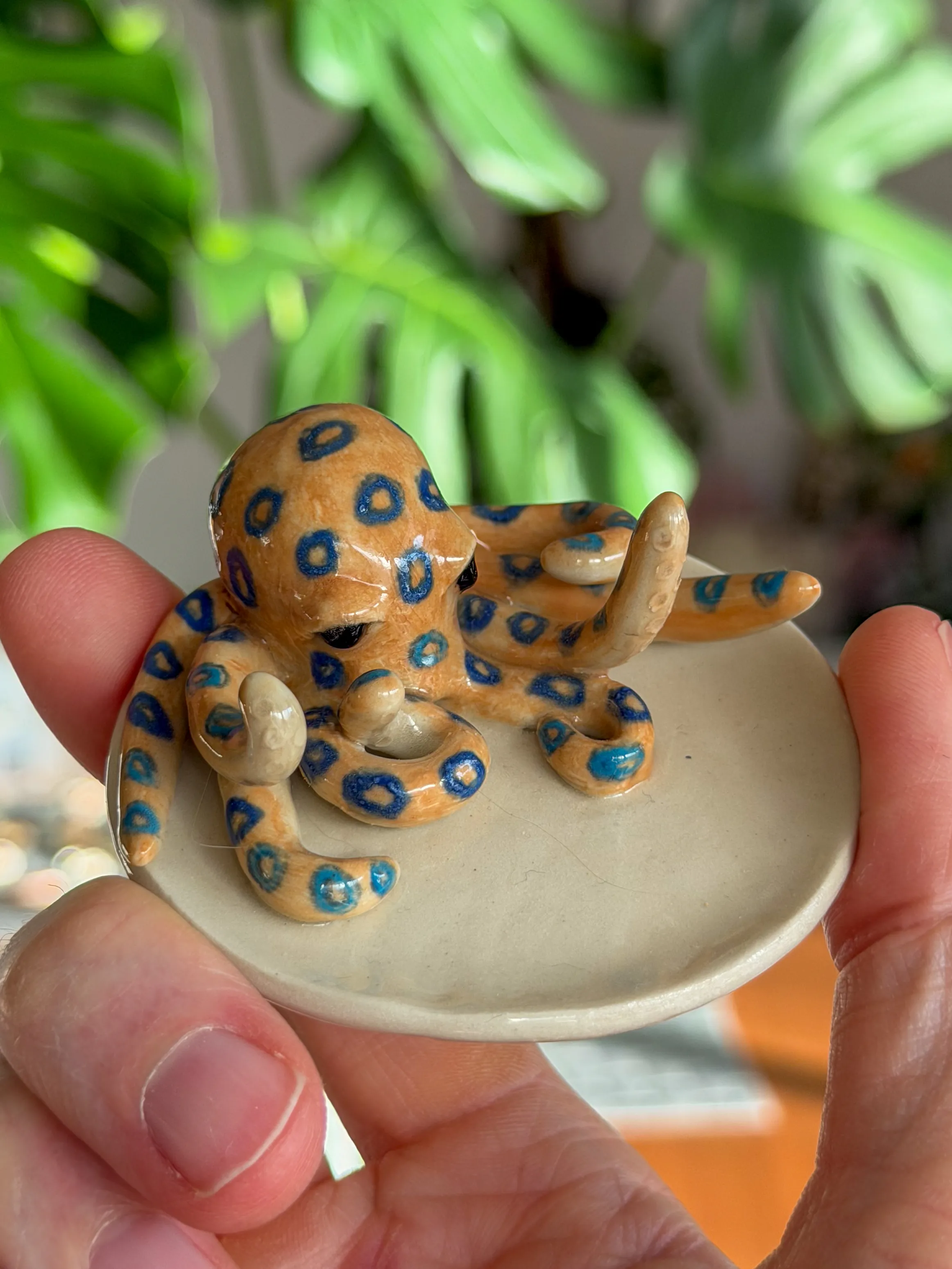 Hand-sculpted ceramic blue-ringed octopus on a small ceramic dish